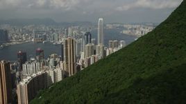 5K stock footage aerial video fly over green mountain to approach Hong Kong Island skyscrapers, China Aerial Stock Footage | SS01_0036