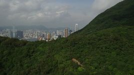 5K stock footage aerial video fly over forest and mountain to reveal skyscrapers on Hong Kong Island, China Aerial Stock Footage | SS01_0038