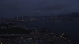 5K stock footage aerial video approach Kowloon and Hong Kong Island skylines from the Port of Hong Kong at night, China Aerial Stock Footage | SS01_0120