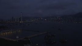 5K stock footage aerial video approach skylines of Kowloon Hong and Kong Island from the port at night, China Aerial Stock Footage | SS01_0121