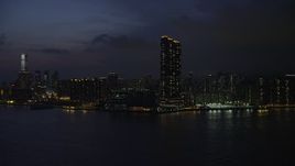 5K stock footage aerial video approach Kowloon skyscraper overlooking Victoria Harbor at night, Hong Kong, China Aerial Stock Footage | SS01_0157