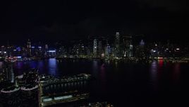 5K stock footage aerial video approach Hong Kong Island skyline from Kowloon piers at night, China Aerial Stock Footage | SS01_0215
