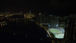 5K stock footage aerial video approach Stonecutters Bridge from waterfront apartment complexes on Tsing Yi Island at night, China Aerial Stock Footage | SS01_0258