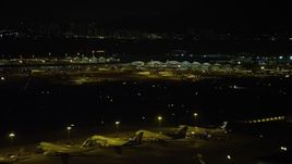 5K stock footage aerial video of Hong Kong International Airport Terminals at night, and tilt to parked airliners, China Aerial Stock Footage | SS01_0280