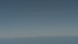 4K stock footage aerial video air-to-air view of a jet airplane contrail flying over mountains in Solano County, California Aerial Stock Footage | WA001_029