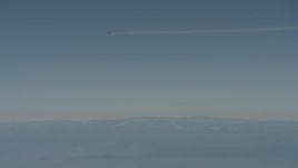4K stock footage aerial video air-to-air of a jet airplane contrail over mountains in the distance, Solano County, California Aerial Stock Footage | WA001_030
