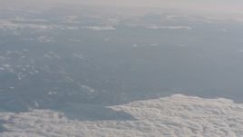 4K stock footage aerial video pan across snowy mountains and clouds in the Sierra Nevada Mountains, California Aerial Stock Footage | WA002_034