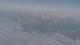 4K stock footage aerial video tilt from a bird's eye of clouds to reveal snowy Sierra Nevada Mountains, California Aerial Stock Footage | WA002_036