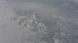 4K stock footage aerial video of Sierra Nevada Mountains below misty clouds, California Aerial Stock Footage | WA002_075
