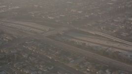 4K stock footage aerial video pan across I-105 to reveal the Lear jet landing gear as the plane approaches Hawthorne Airport, California Aerial Stock Footage | WA003_026