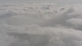 4K stock footage aerial video tilt up while flying over a layer of clouds over Washington Aerial Stock Footage | WA004_046