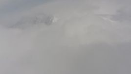 4K stock footage aerial video fly over clouds toward a snowy mountain in the background, Washington Aerial Stock Footage | WA004_083