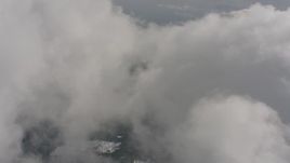 4K stock footage aerial video fly over clouds and snowy forest to approach a hole in the clouds, Washington Aerial Stock Footage | WA004_090