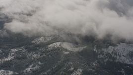 4K stock footage aerial video flyby clouds to reveal snow and forest below in Washington Aerial Stock Footage | WA004_092