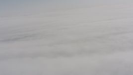 4K stock footage aerial video tilt from a bird's eye view of clouds to a wider view of the cloud cover over Oregon Aerial Stock Footage | WA004_101