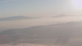 4K stock footage aerial video tilt from a bird's eye of clouds to reveal mountains at sunset in Southern California Aerial Stock Footage | WA005_013