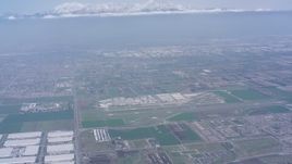 4K stock footage aerial video tilt from construction areas to reveal Chino Airport and snowy mountains, Chino, California Aerial Stock Footage | WA007_044