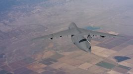 4K stock footage aerial video of passing behind a Lockheed C-5 flying over farmland in Northern California Aerial Stock Footage | WAAF01_C019_0117VJ