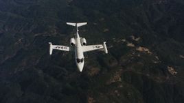 4K stock footage aerial video of panning across mountains to reveal a Learjet C-21 in Northern California Aerial Stock Footage | WAAF02_C019_0117JN_S003