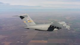 4K stock footage aerial video of a Boeing C-17 flying above farmland in Northern California Aerial Stock Footage | WAAF05_C015_01189N