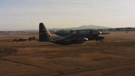 4K stock footage aerial video of a Lockheed Martin C-130J lifting off from Travis Air Force Base at sunset, California Aerial Stock Footage | WAAF06_C002_0119TW