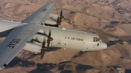 4K stock footage aerial video of a Lockheed Martin C-130J in flight over brown hills at sunset, Northern California Aerial Stock Footage | WAAF06_C013_0119HX