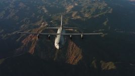 4K stock footage aerial video of a reverse view of a Lockheed Martin C-130J over mountains at sunset in Northern California Aerial Stock Footage | WAAF06_C041_0119KA