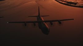 4K stock footage aerial video reveal a Lockheed Martin C-130J flying over a bay at sunset, Northern California Aerial Stock Footage | WAAF06_C091_0119E1