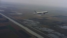 4K stock footage aerial video of a Boeing C-32 in flight over a river and farms in Northern California Aerial Stock Footage | WAAF08_C015_01193S