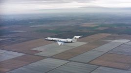 4K stock footage aerial video of a Gulfstream C-37A flying over covered fields in Northern California Aerial Stock Footage | WAAF08_C056_0120GH