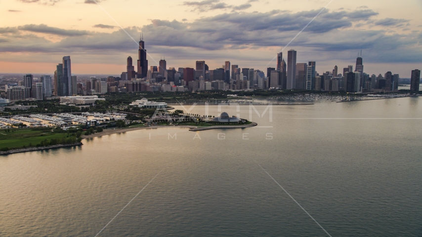 Downtown Chicago skyline and the Adler Planetarium seen from Lake Michigan, at sunset, Illinois Aerial Stock Photo AX0003_029.0000000F | Axiom Images
