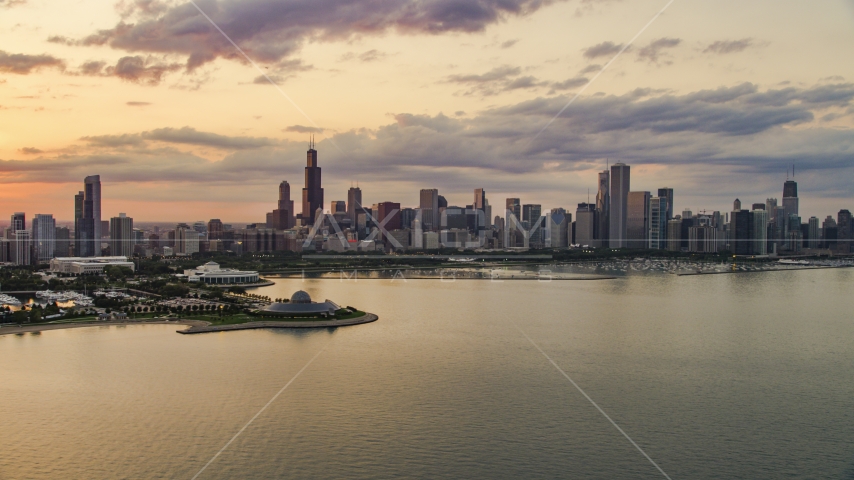 A view of Downtown Chicago skyline and the Adler Planetarium seen from Lake Michigan, at sunset, Illinois Aerial Stock Photo AX0003_029.0000188F | Axiom Images