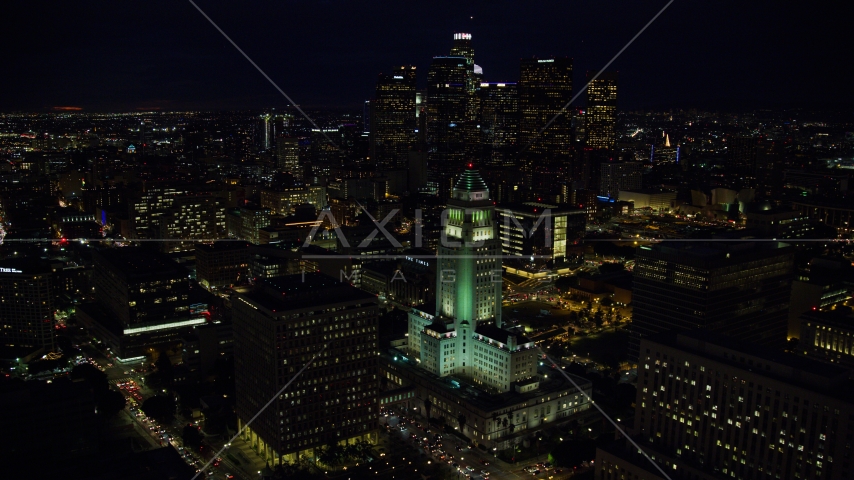 City Hall and the city's skyscrapers at night in Downtown Los Angeles, California Aerial Stock Photo AX0158_103.0000016 | Axiom Images