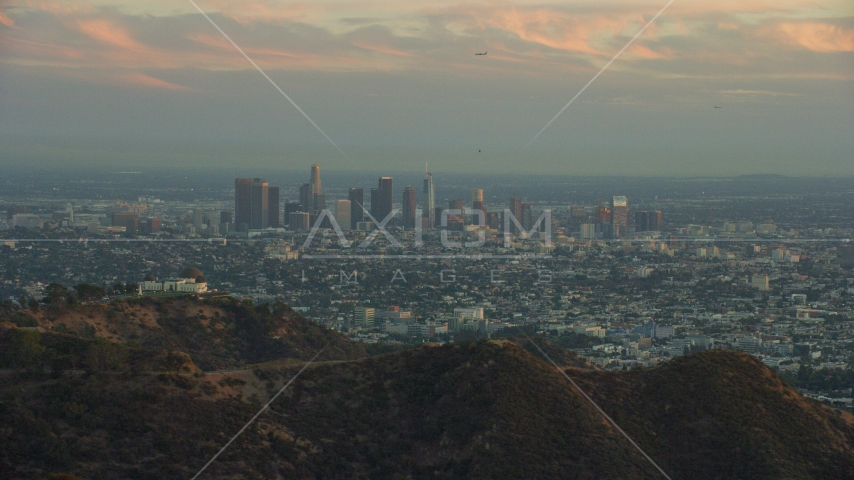 The skyline of Downtown Los Angeles, California at twilight and Griffith Observatory Aerial Stock Photo AX0162_105.0000154 | Axiom Images