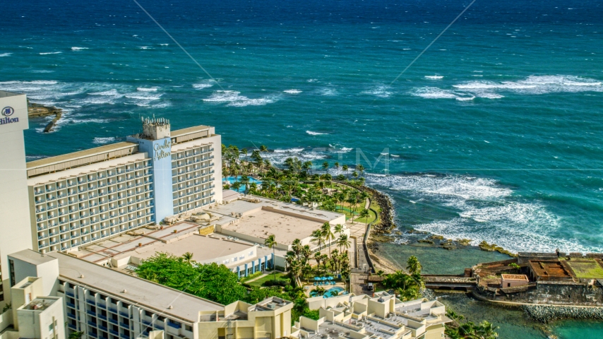 Caribe Hilton Hotel oceanside resort in the Caribbean, San Juan, Puerto Rico Aerial Stock Photo AX101_004.0000122F | Axiom Images