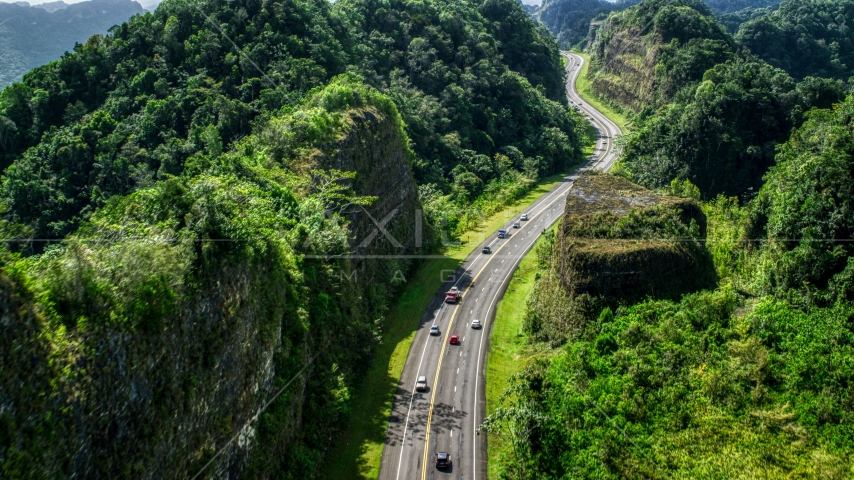 Light traffic on a highway lush green mountains, Karst Forest, Puerto Rico Aerial Stock Photo AX101_082.0000065F | Axiom Images