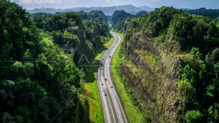 A highway through lush green mountains, Karst Forest, Puerto Rico Aerial Stock Photo AX101_083.0000200F | Axiom Images