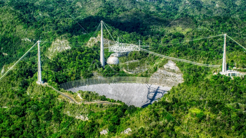 Wide shot of the Arecibo Observatory among lush green forests, Puerto Rico  Aerial Stock Photo AX101_090.0000276F | Axiom Images