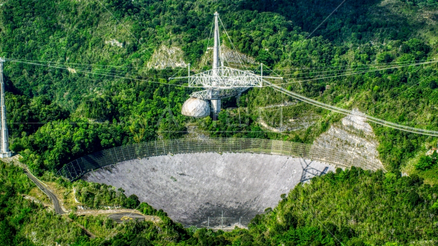 A view of the Arecibo Observatory in the lush green Karst forest, Puerto Rico Aerial Stock Photo AX101_091.0000000F | Axiom Images