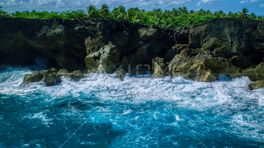 Coastal rock formations and caves, and crashing ocean waves in Arecibo, Puerto Rico  Aerial Stock Photo AX101_163.0000000F | Axiom Images