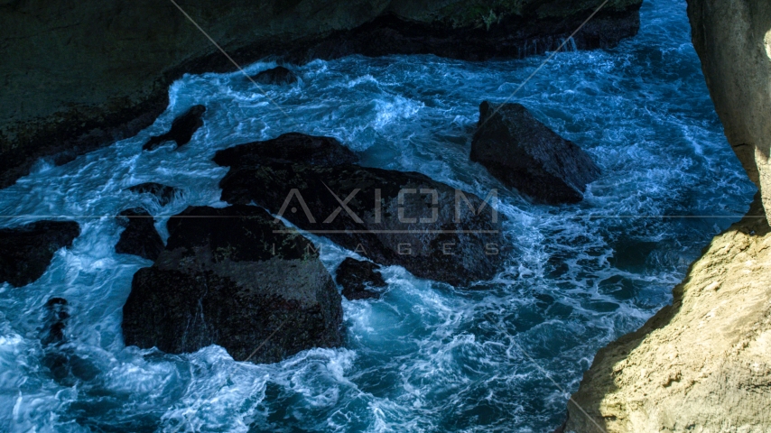 Churning water and rocks in a coastal sea cave, Arecibo, Puerto Rico Aerial Stock Photo AX101_167.0000171F | Axiom Images