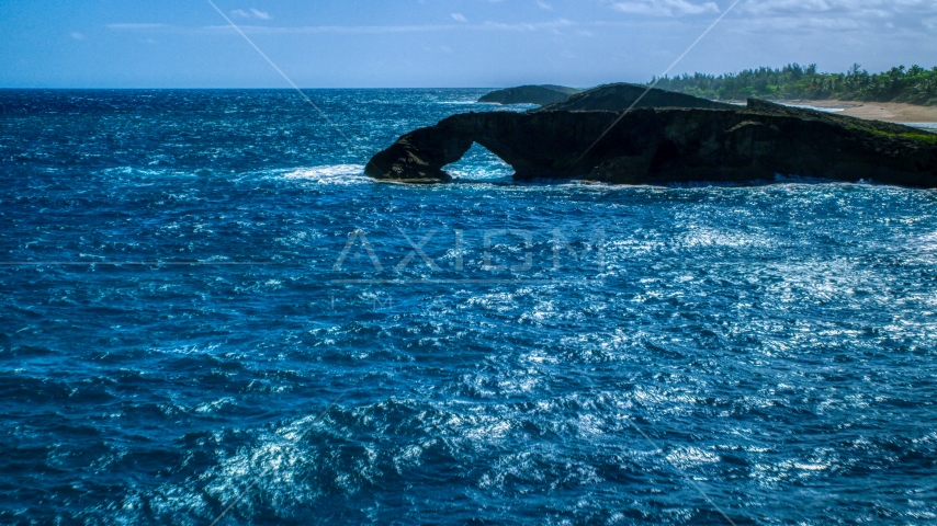 An arched rock formation in crystal blue water, Arecibo, Puerto Rico Aerial Stock Photo AX101_168.0000129F | Axiom Images