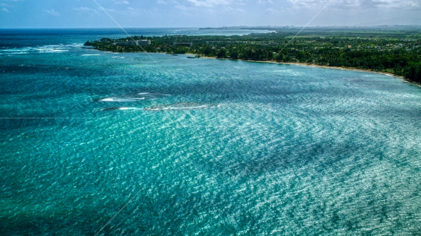 Caribbean island coastal community seen across blue water in Dorado, Puerto Rico Aerial Stock Photo AX101_216.0000000F | Axiom Images