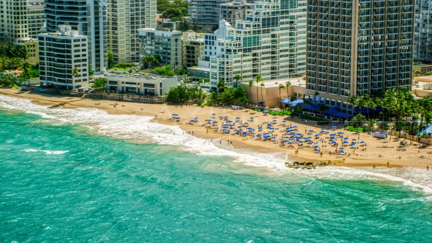 Tourists on a beach enjoying clear blue waters, San Juan, Puerto Rico Aerial Stock Photo AX102_004.0000000F | Axiom Images