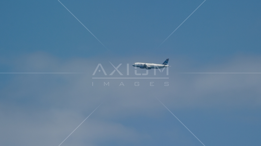A passenger plane and blue skies, Carolina, Puerto Rico Aerial Stock Photo AX102_014.0000199F | Axiom Images
