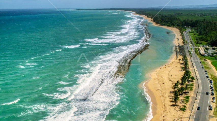Waves rolling toward the beach and highway, Loiza, Puerto Rico Aerial Stock Photo AX102_018.0000143F | Axiom Images