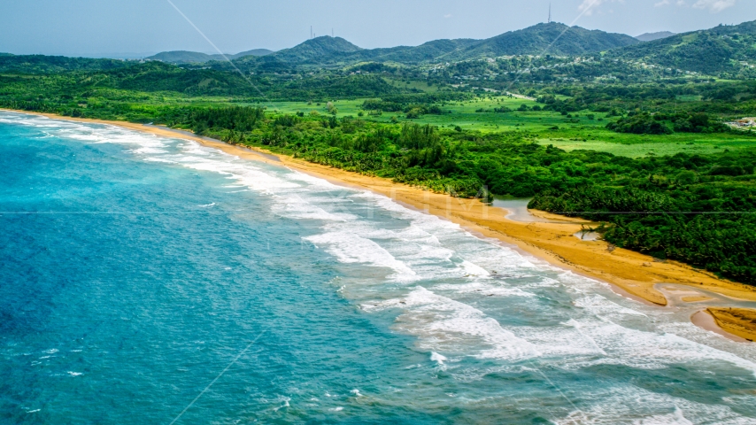 Ocean waves rolling toward an empty beach in Luquillo, Puerto Rico Aerial Stock Photo AX102_051.0000227F | Axiom Images