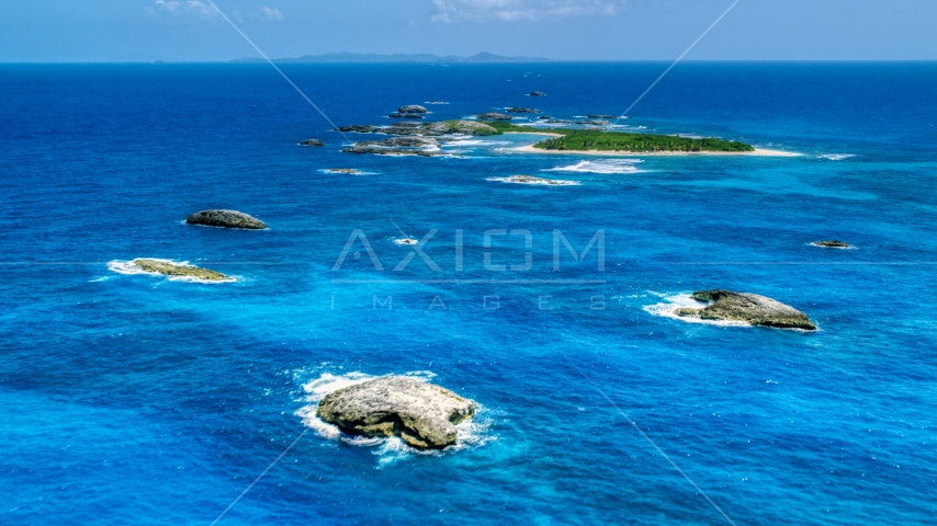 Tiny green Caribbean island in tropical blue waters, and smaller rocky islands, Puerto Rico  Aerial Stock Photo AX102_088.0000024F | Axiom Images
