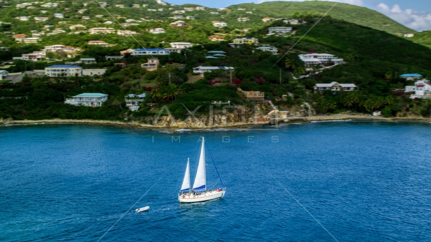 Sailboat near the island coast and oceanfront homes in Southside, St Thomas, the US Virgin Islands  Aerial Stock Photo AX102_234.0000199F | Axiom Images