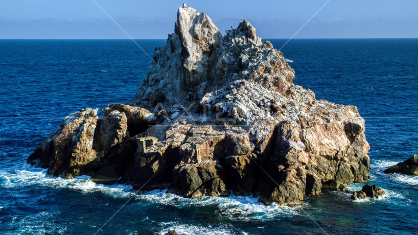 A jagged rock formation in Caribbean blue waters, St Thomas Aerial Stock Photo AX103_082.0000090F | Axiom Images